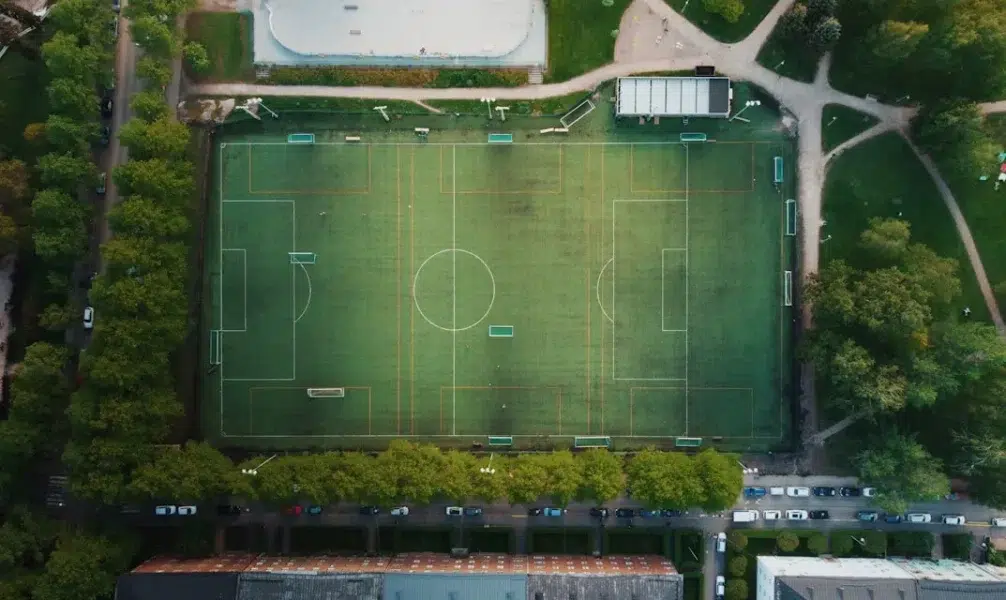 Image of a football pitch from top angle Photo by Mika Korhonen on Unsplash