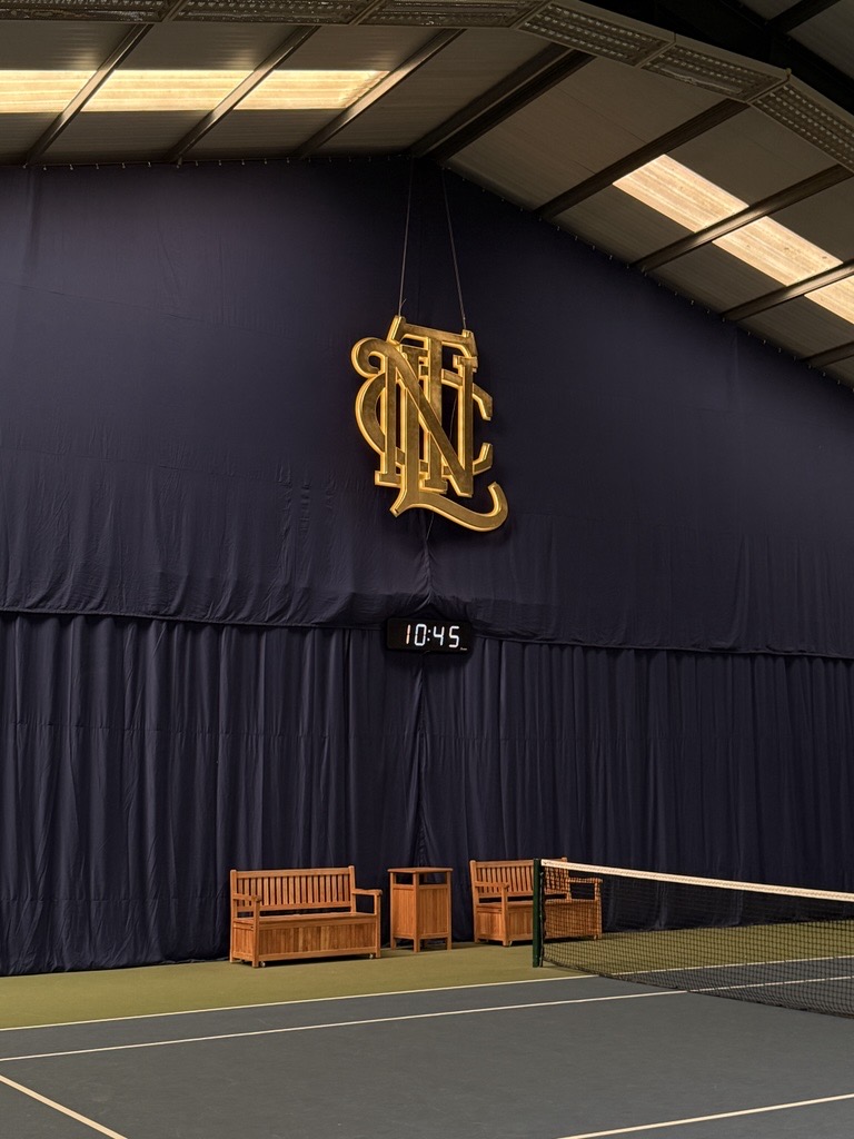 Indoor tennis backdrop featuring the Northern Lawn Tennis Club logo