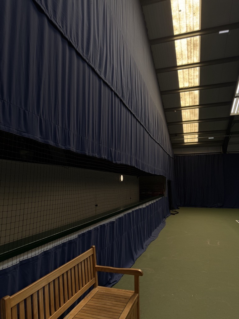 Indoor tennis backdrop curtain system