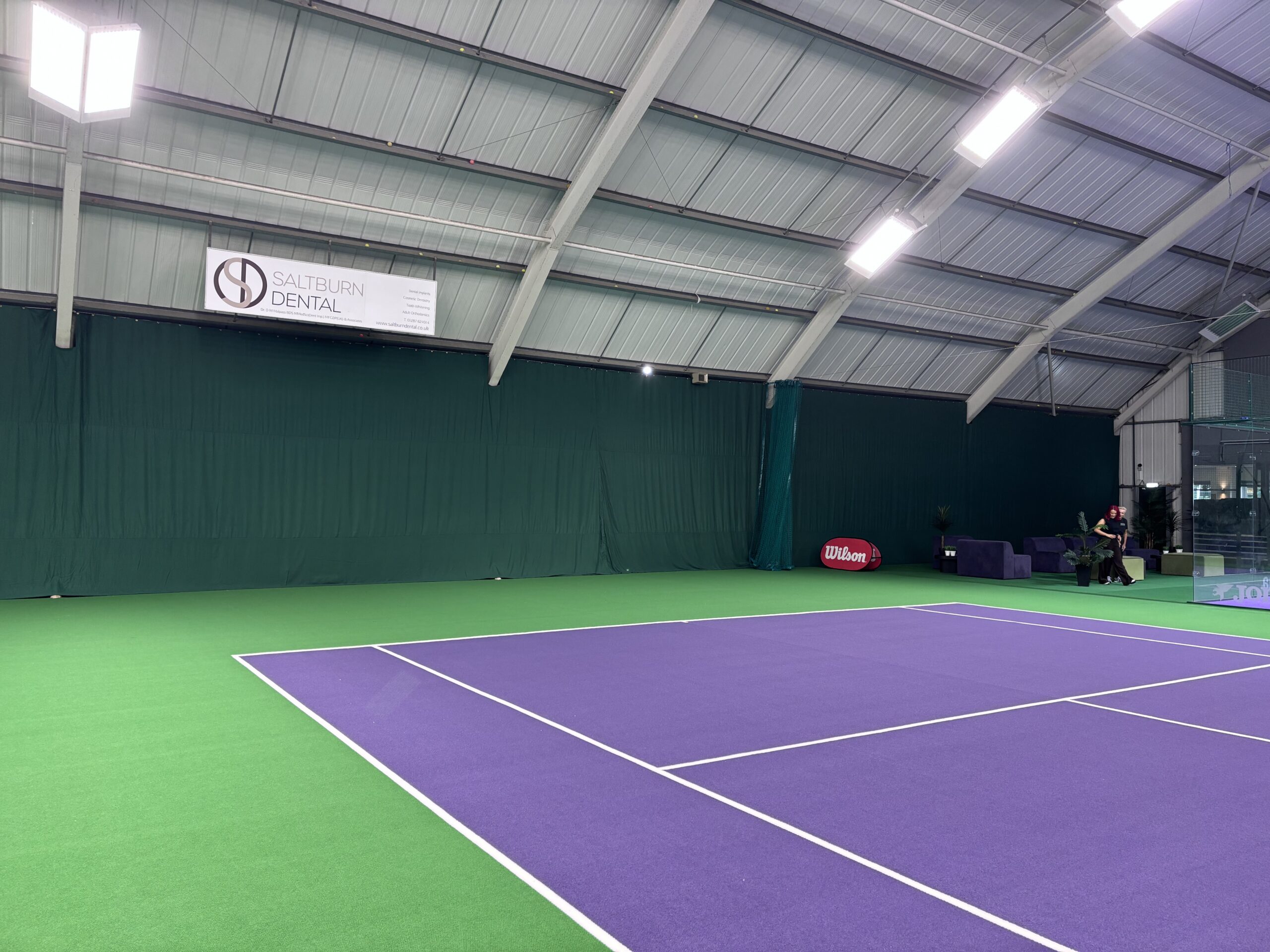 Divider netting installed between indoor racket sport court areas