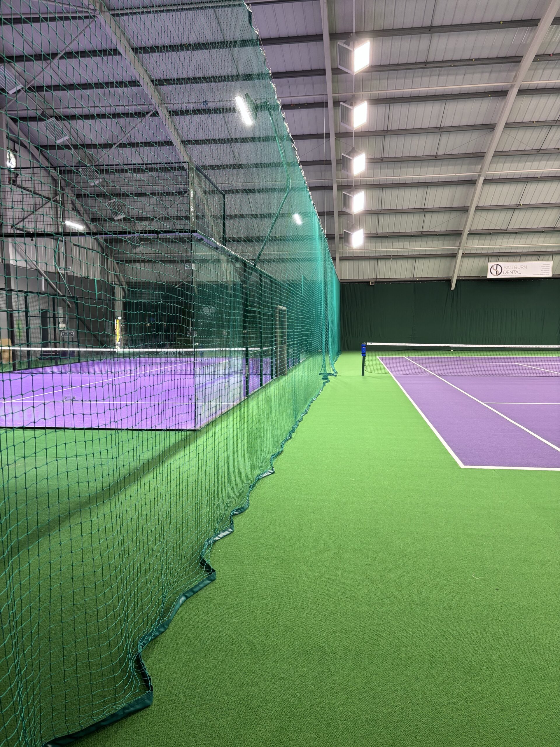Indoor tennis divider and backdrop installation